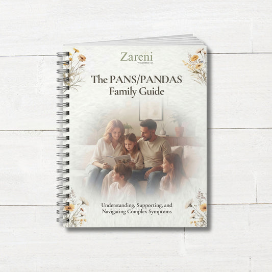 The PANS/PANDAS Family Guide spiral bound workbook cover by Zareni Wellness on white wooden background